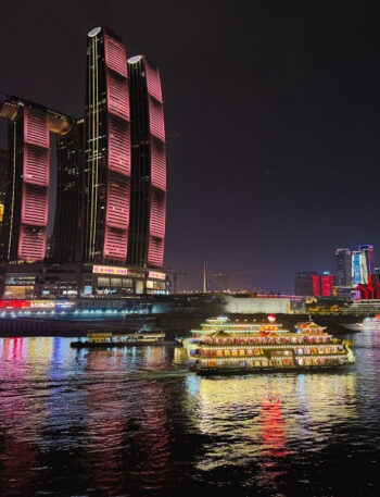 Skyline of Chongqing in China by night with reflection of lit up buildings on the river.